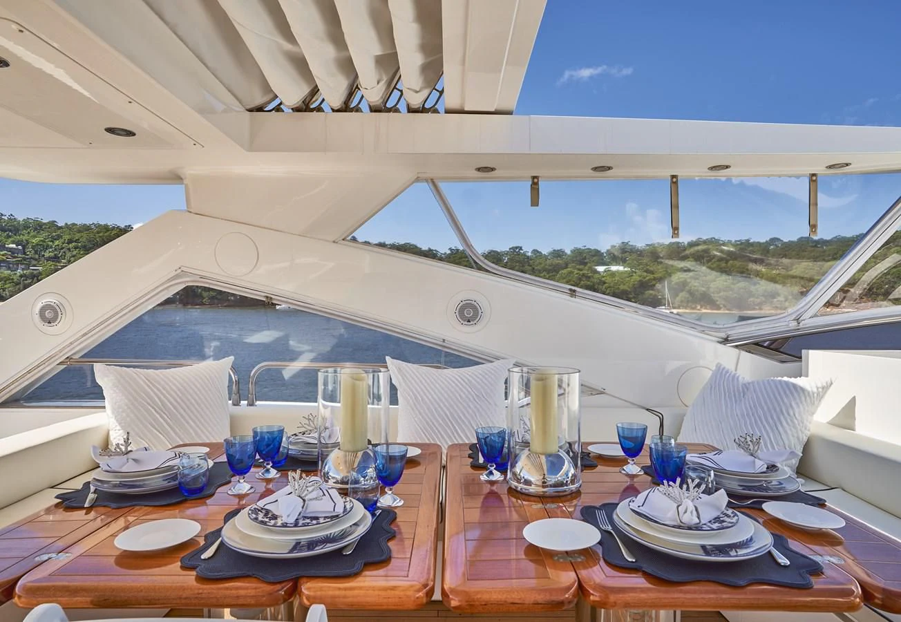 a table set with plates and glasses aboard CHAOS Yacht for Sale