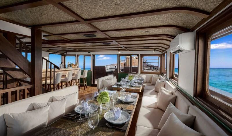 a room with a table chairs and a couch aboard SAMSARA SAMUDRA Yacht for Sale