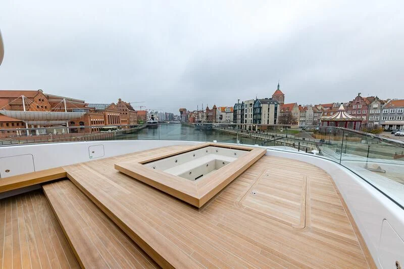 a large wooden deck overlooking a city aboard ACE Yacht for Sale