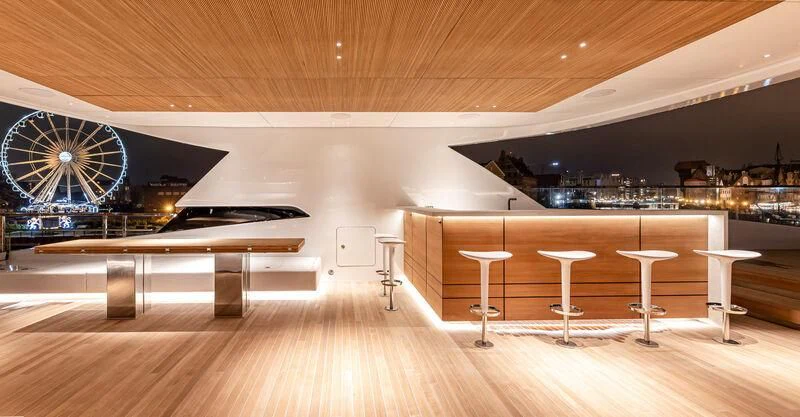 a room with tables and stools aboard ACE Yacht for Sale