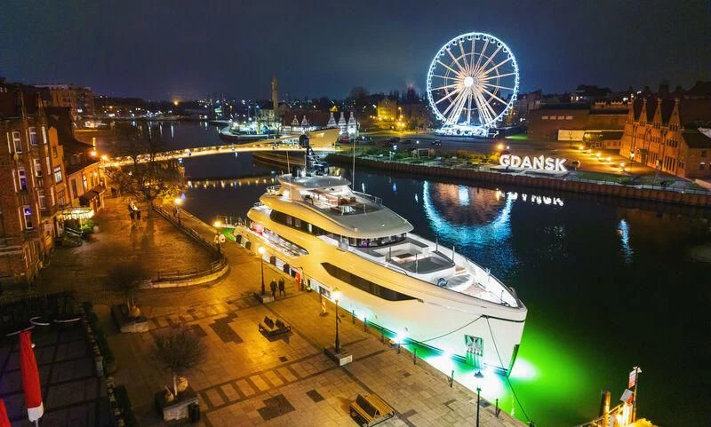 a ferris wheel and a river at night aboard ACE Yacht for Sale
