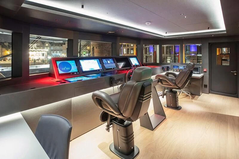 a room with a large table and chairs and a tv aboard ACE Yacht for Sale