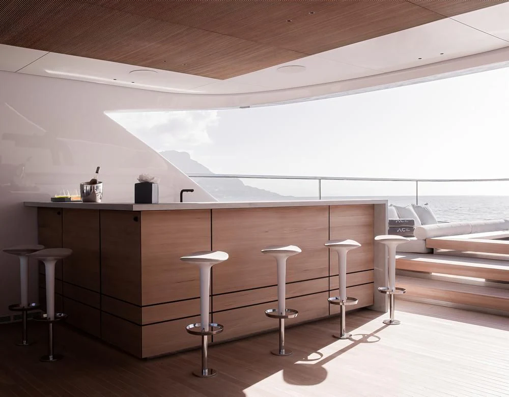 a room with a table and stools aboard ACE Yacht for Sale