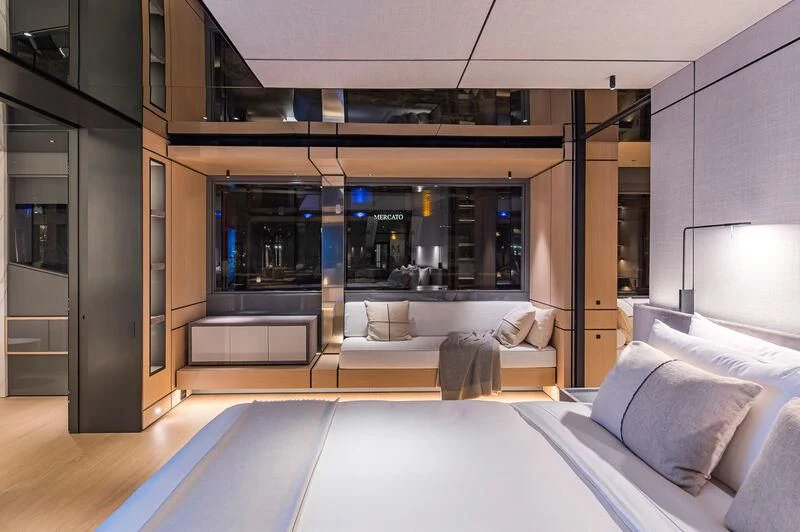 a room with a bed and a large window aboard ACE Yacht for Sale