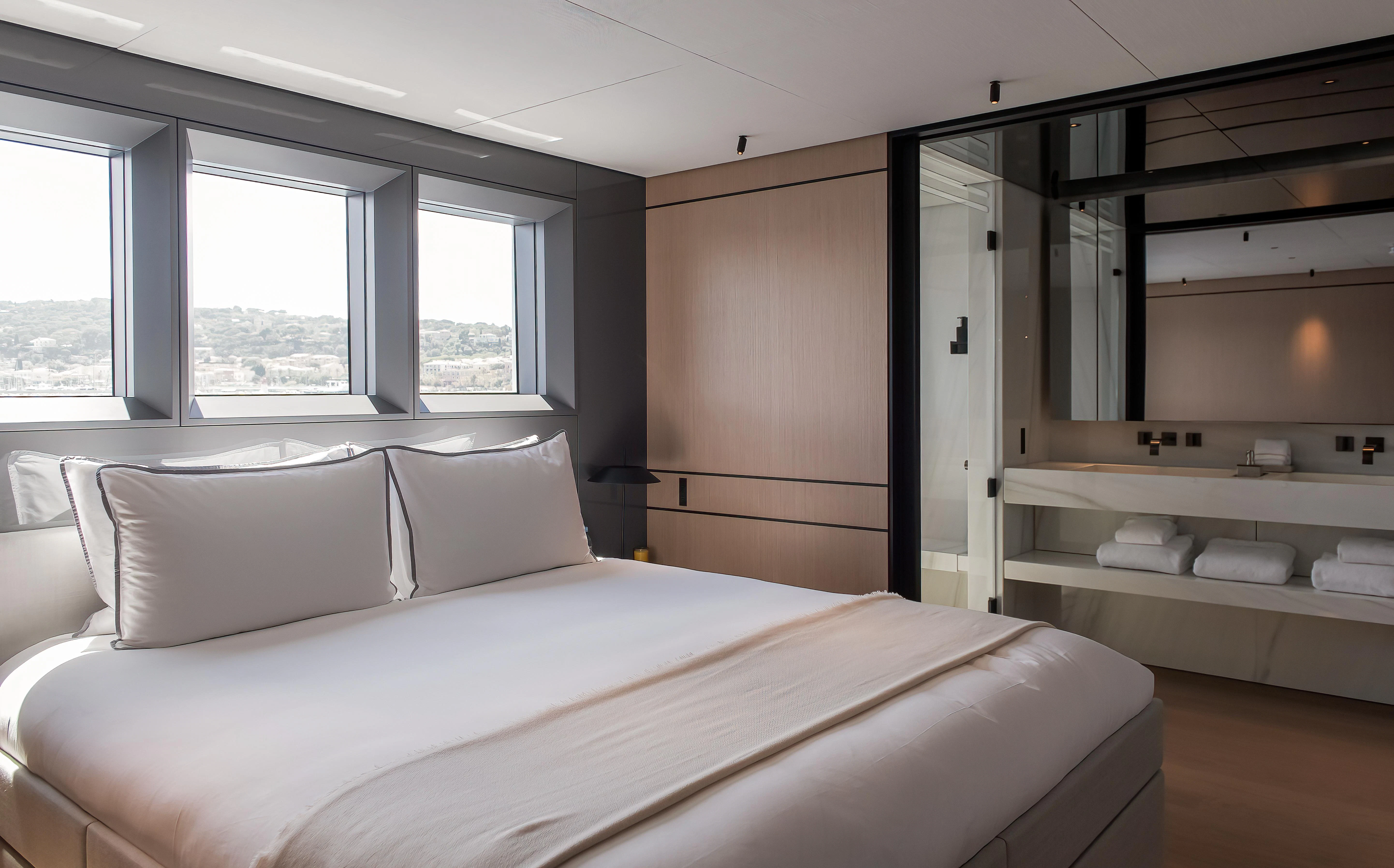 a room with a bed and a window aboard ACE Yacht for Sale