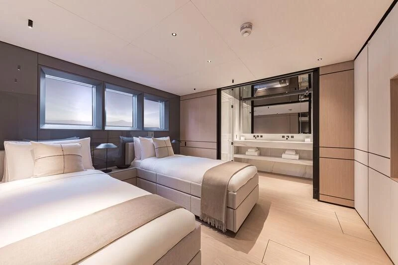 a room with two beds and a tv aboard ACE Yacht for Sale