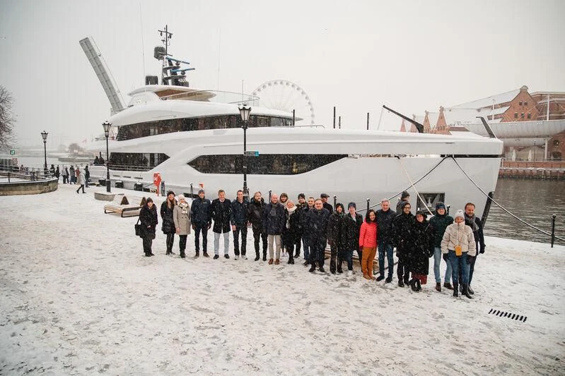 a group of people standing in front of a large ship aboard ACE Yacht for Sale