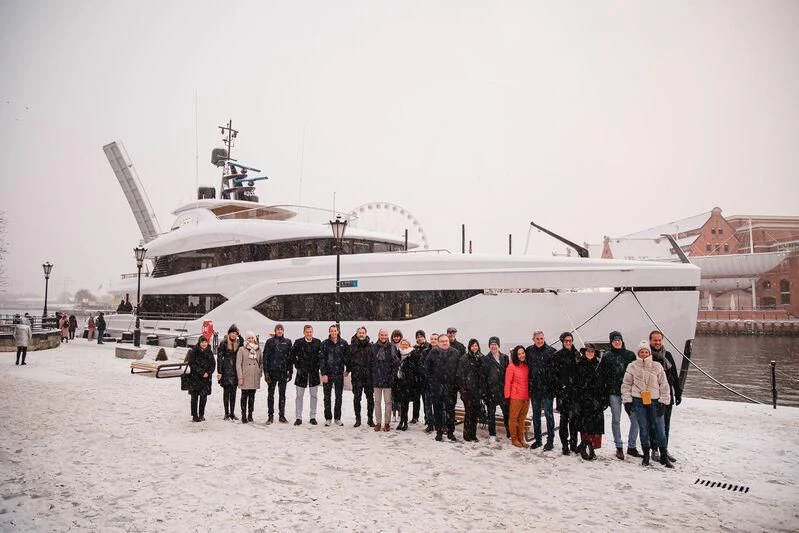 a group of people standing in front of a large ship aboard ACE Yacht for Sale