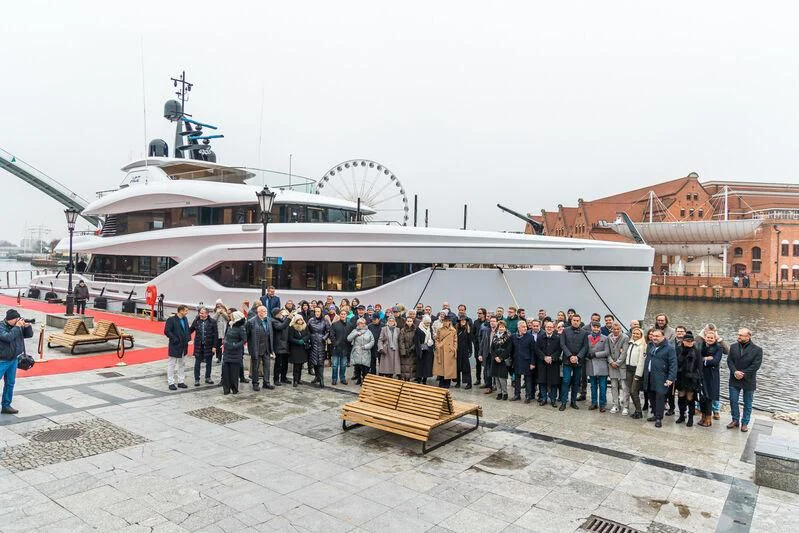 a group of people standing outside of a large boat aboard ACE Yacht for Sale
