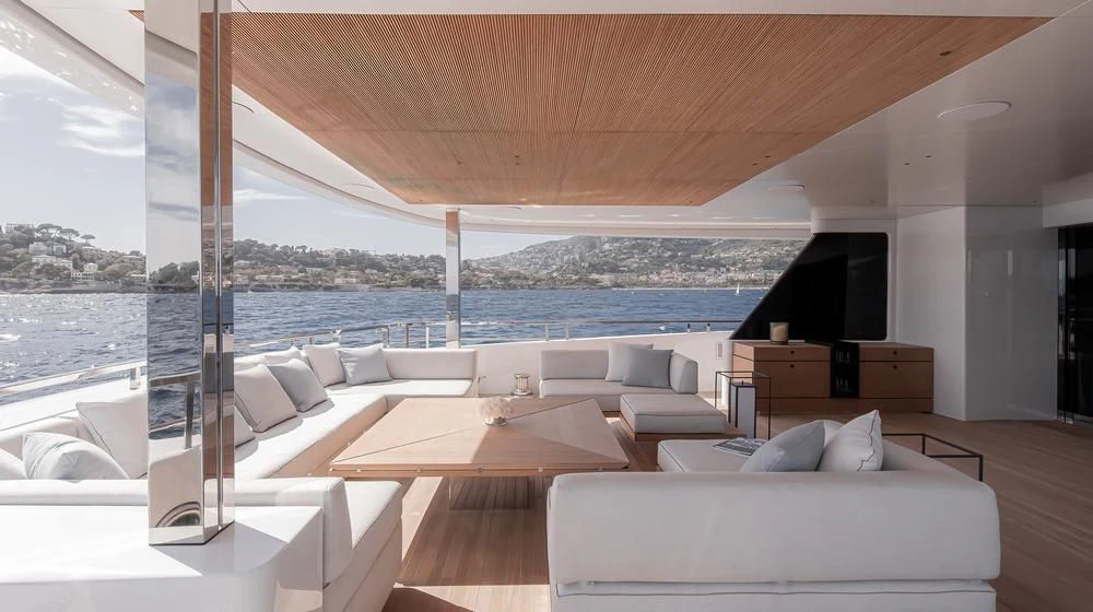 a room with a couch and a tv on the wall aboard ACE Yacht for Sale