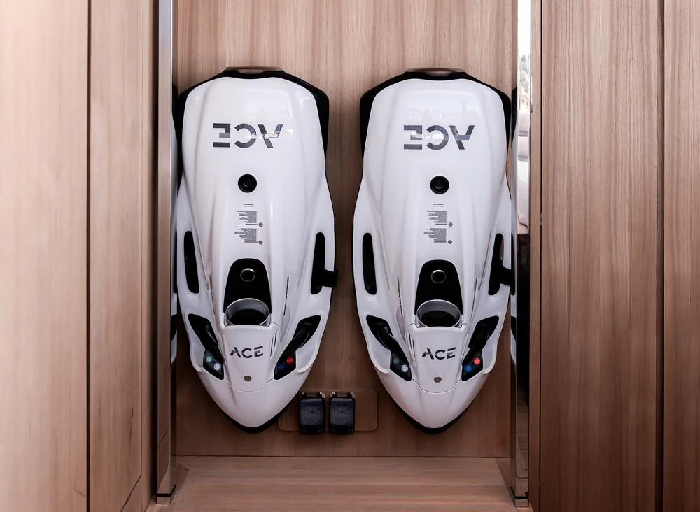 a couple of white and black remotes on a shelf aboard ACE Yacht for Sale