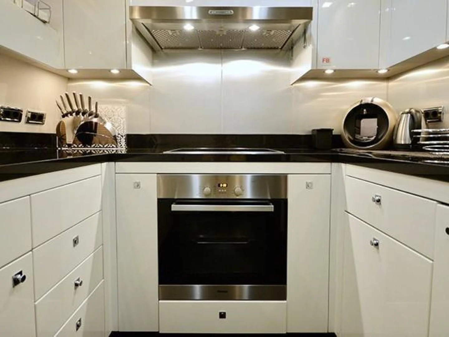 a kitchen with white cabinets aboard EXIMIUS Yacht for Sale