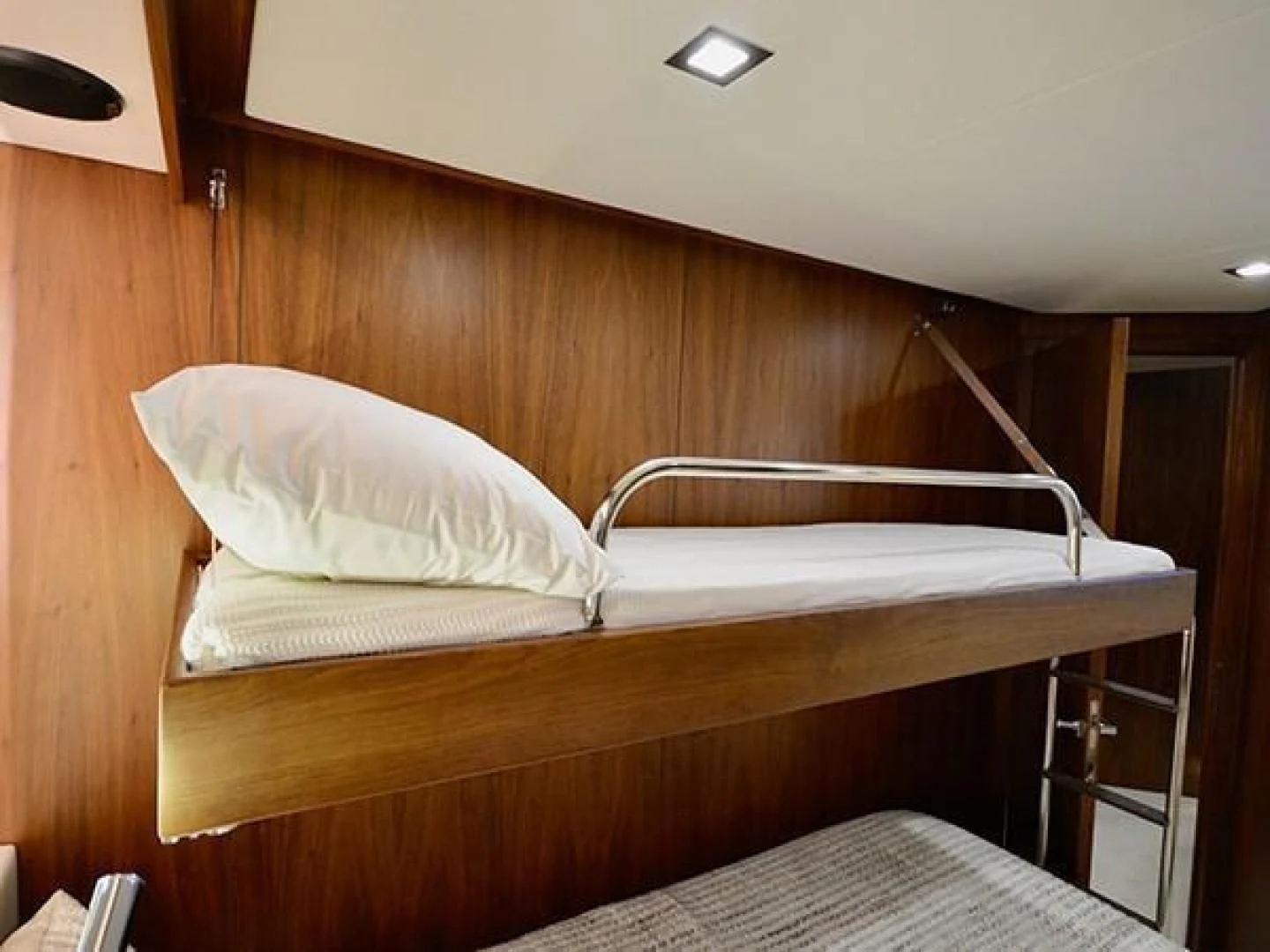 a bed with a white pillow aboard EXIMIUS Yacht for Sale