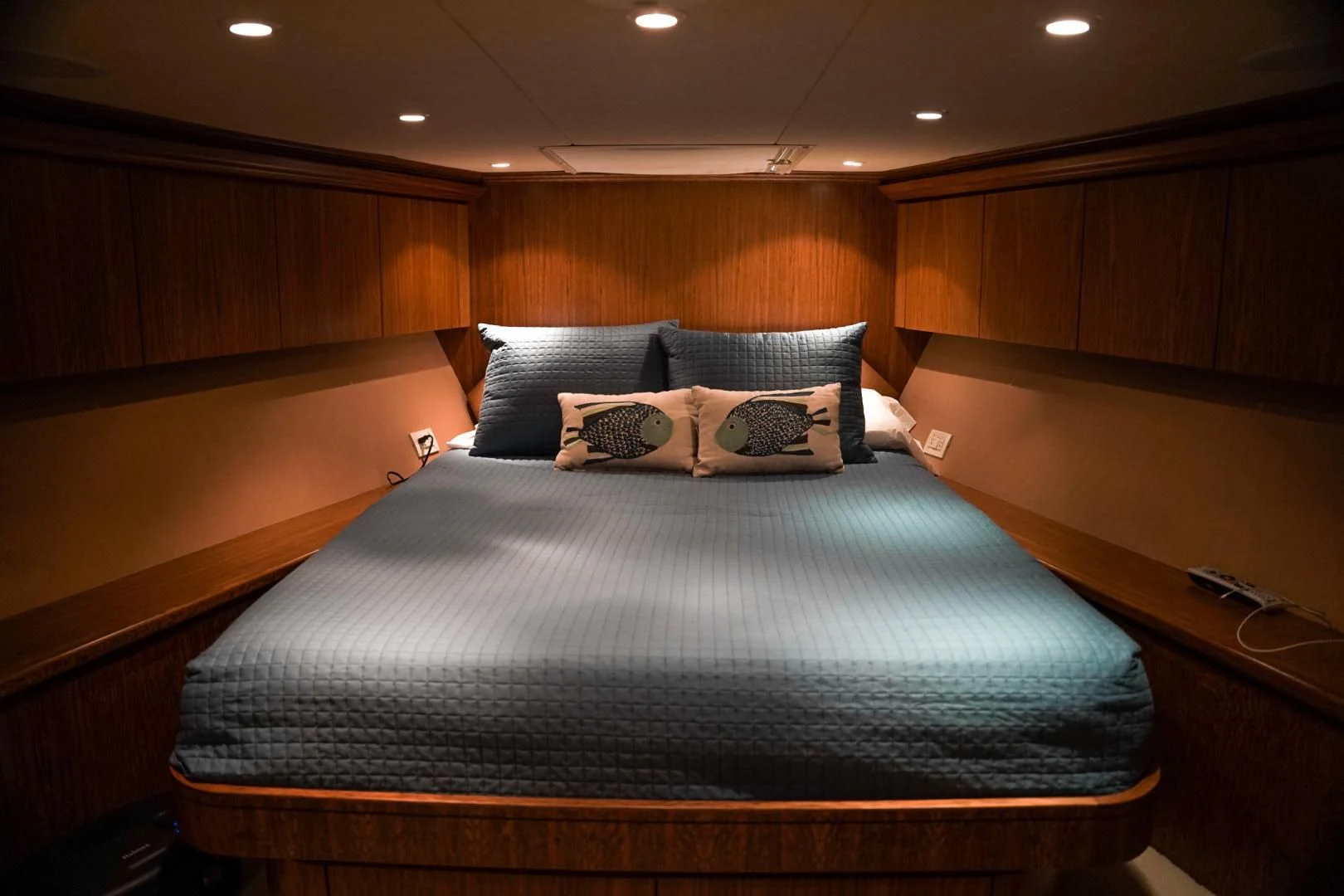a bed with a blue and white comforter and pillows aboard HAU TREE Yacht for Sale