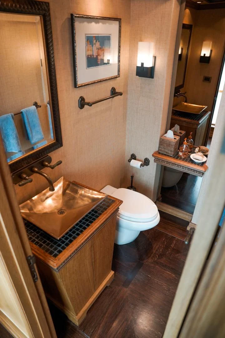 a bathroom with a sink toilet and a mirror aboard HAU TREE Yacht for Sale