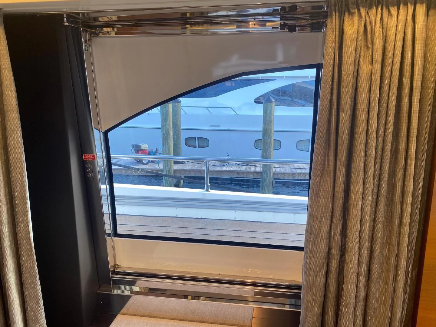 a window with a view of a beach and water aboard LA TACHE Yacht for Sale