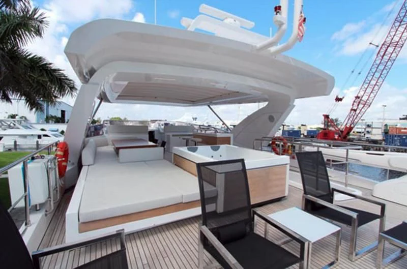a deck with a large white building and a crane in the background aboard LA TACHE Yacht for Sale