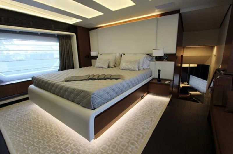 a bedroom with a bed and a window aboard LA TACHE Yacht for Sale