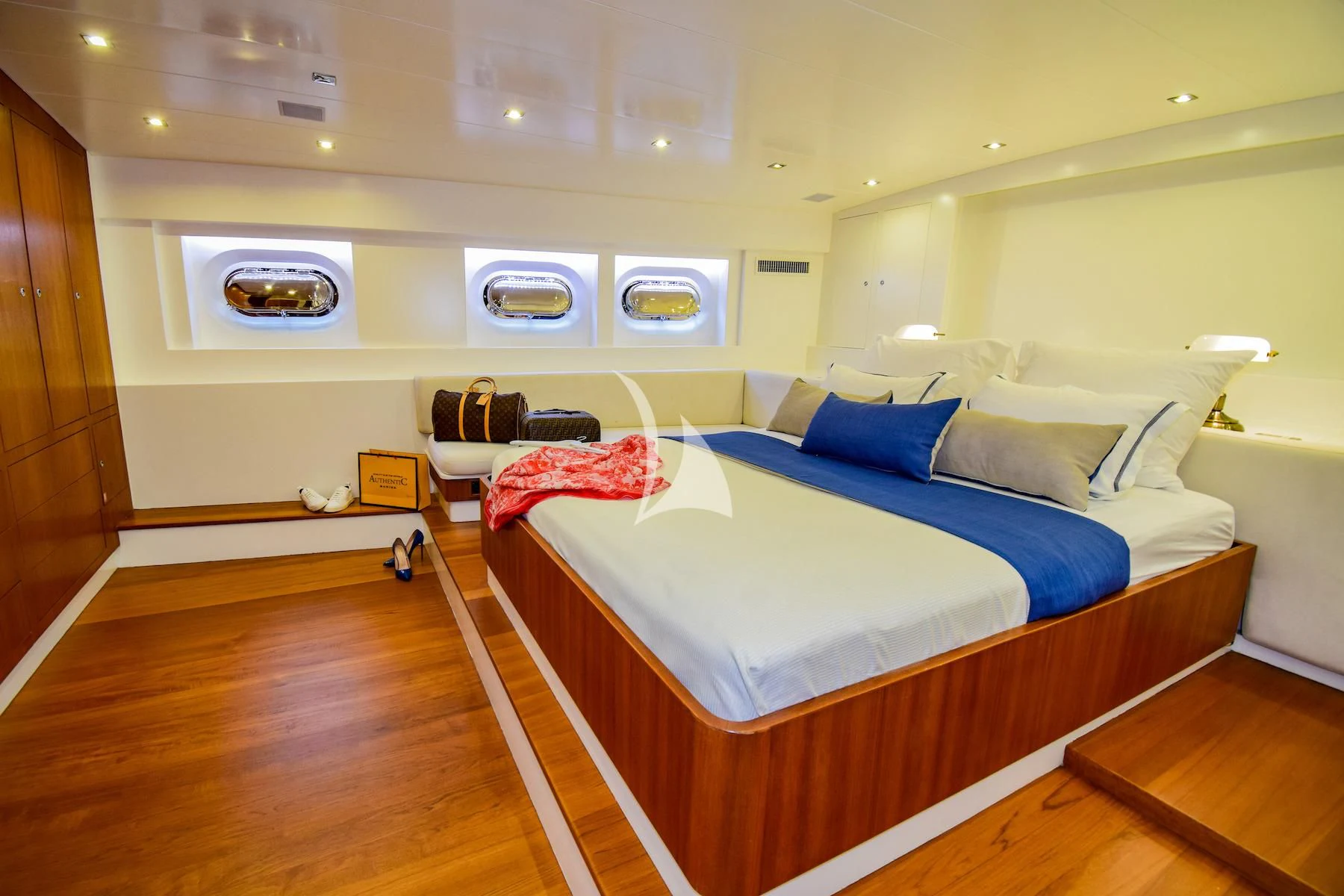 a bedroom with a bed and a chair aboard UBI BENE Yacht for Charter