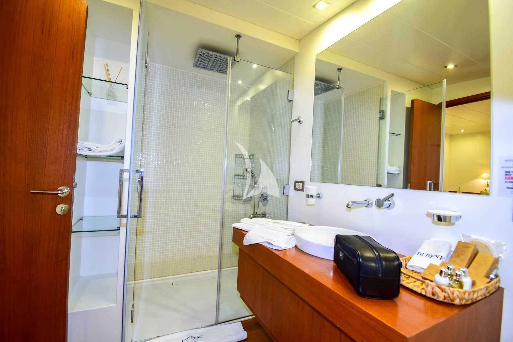 a bathroom with a countertop sink and a shower unit aboard UBI BENE Yacht for Charter