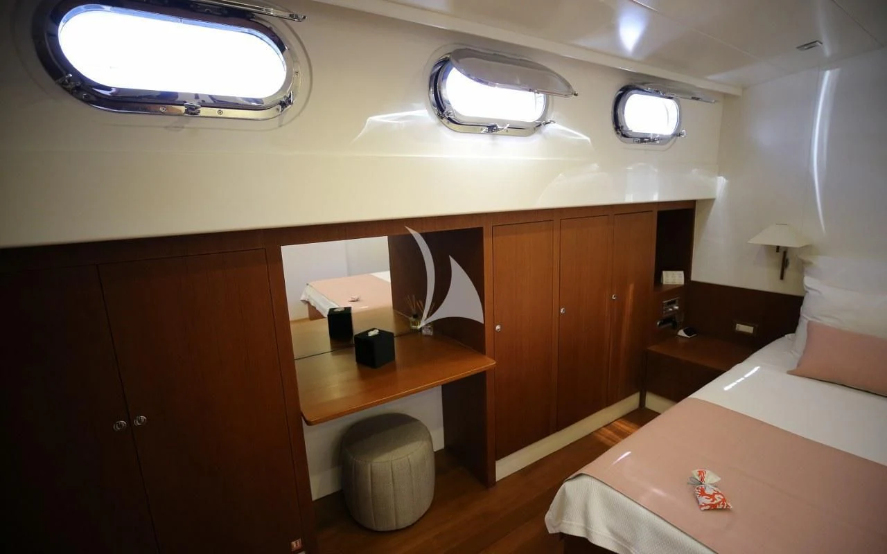 a room with a bed and desk aboard UBI BENE Yacht for Charter