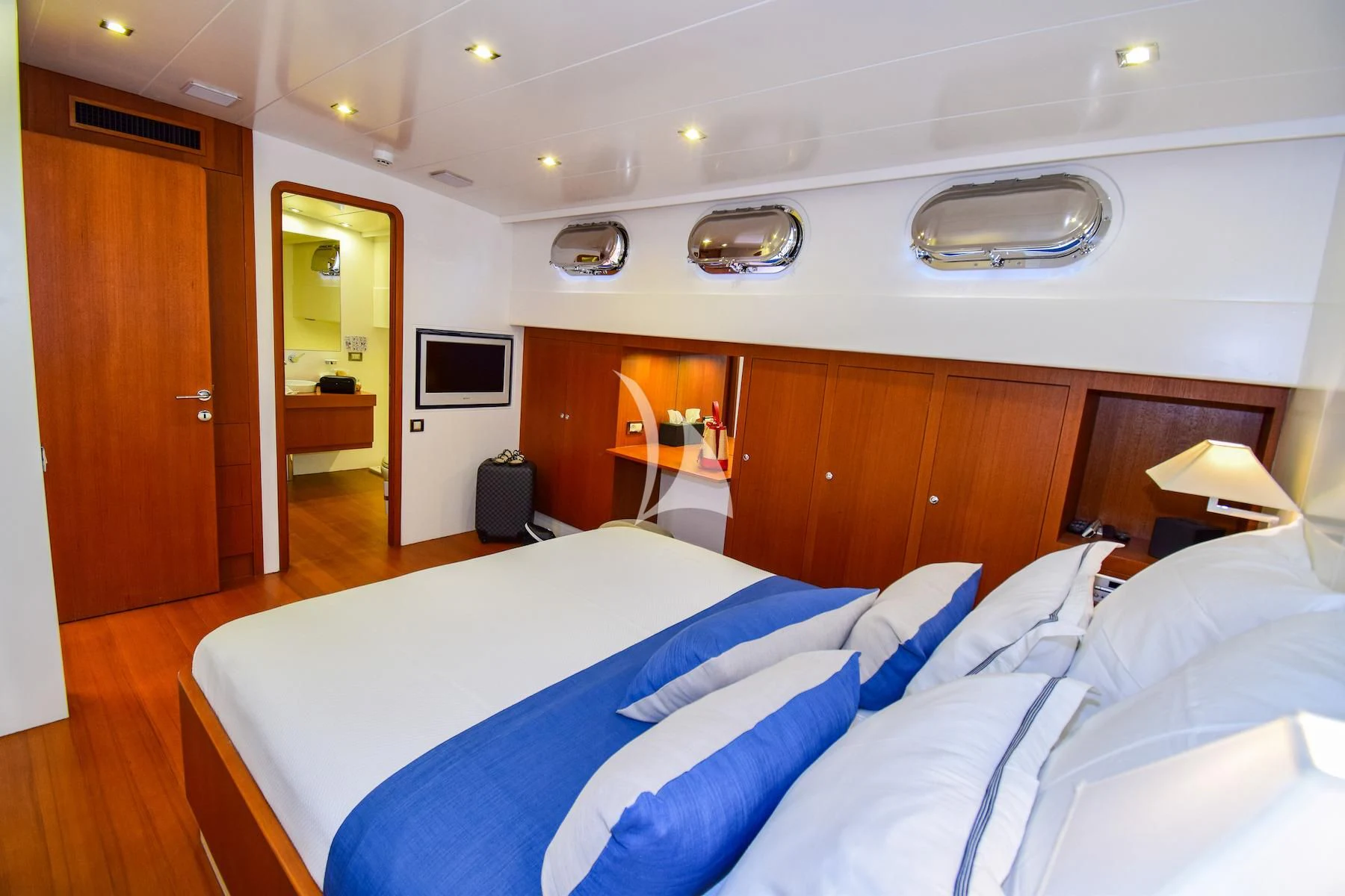 a room with a bed and a television aboard UBI BENE Yacht for Charter