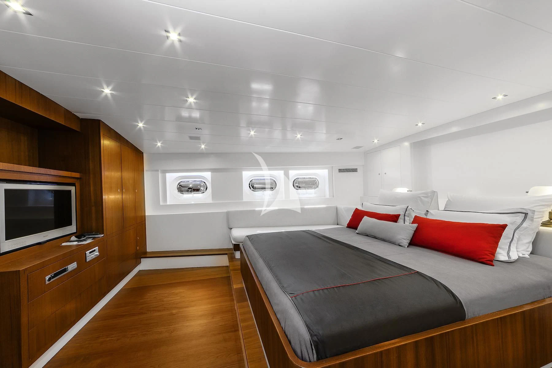 a bedroom with a bed and a tv aboard UBI BENE Yacht for Charter
