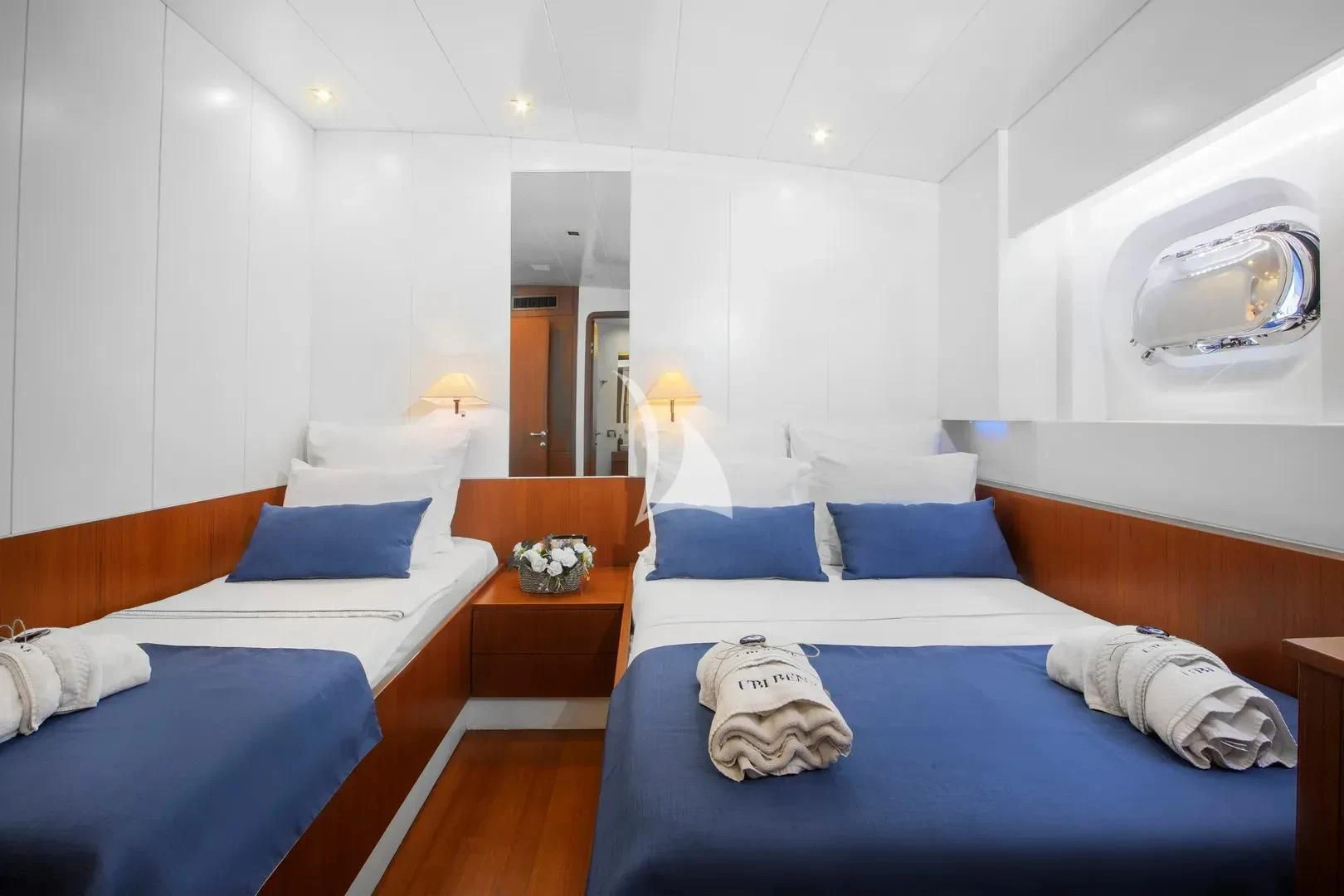 a room with beds and a table aboard UBI BENE Yacht for Charter