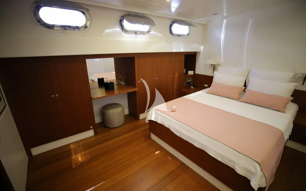 a room with a bed and desk aboard UBI BENE Yacht for Charter