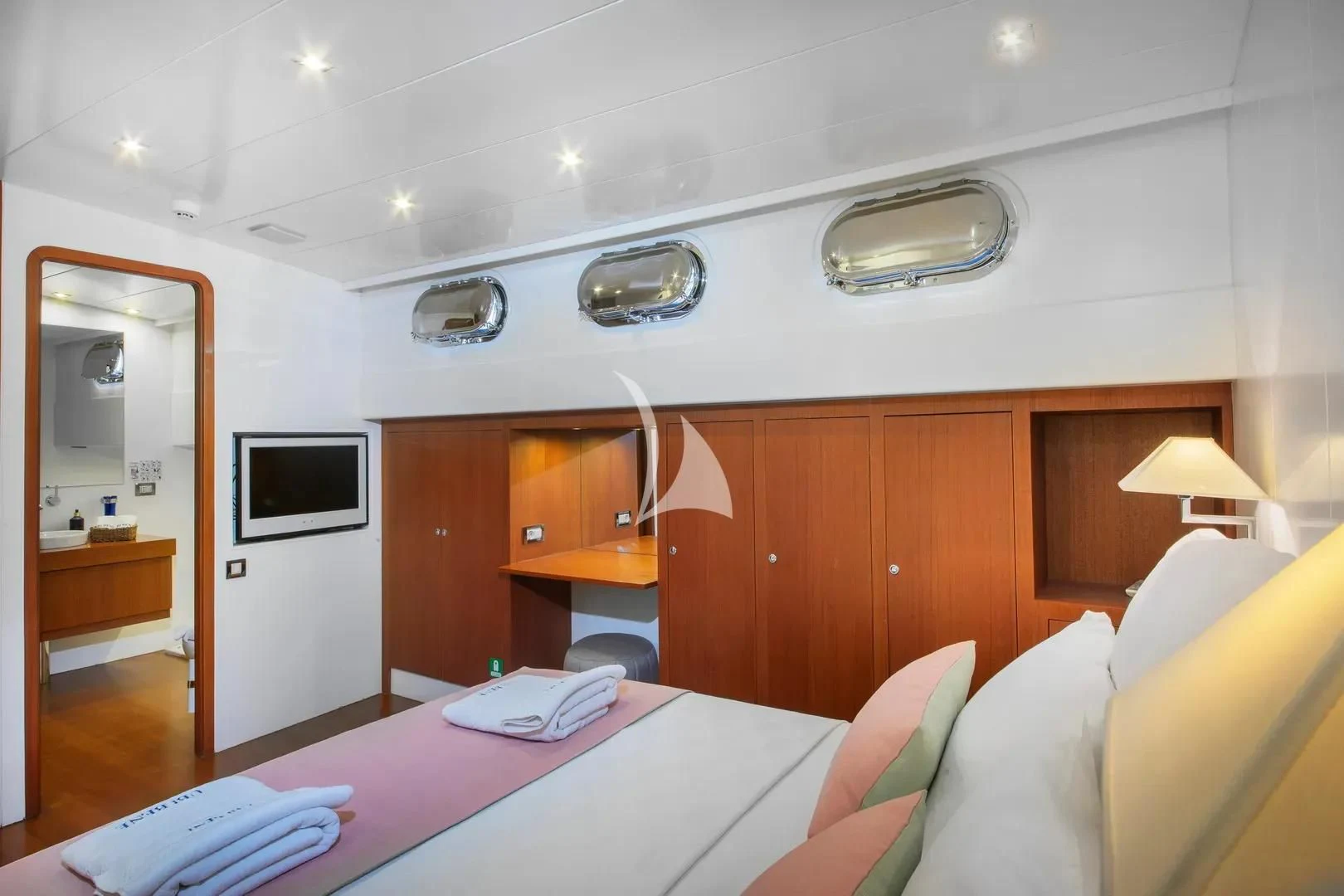a room with a bed and a television aboard UBI BENE Yacht for Charter