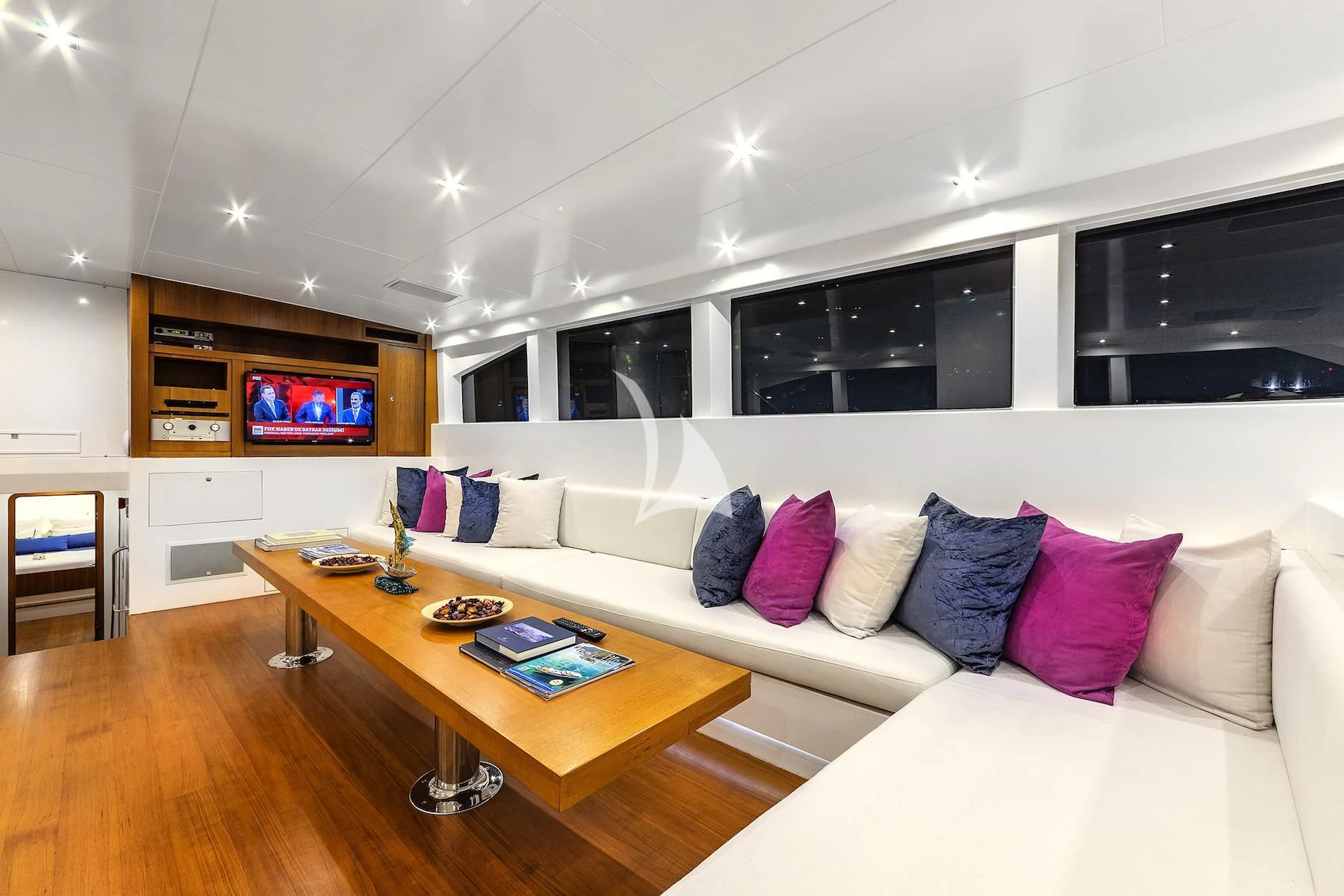 a living room with a white couch and a tv aboard UBI BENE Yacht for Charter