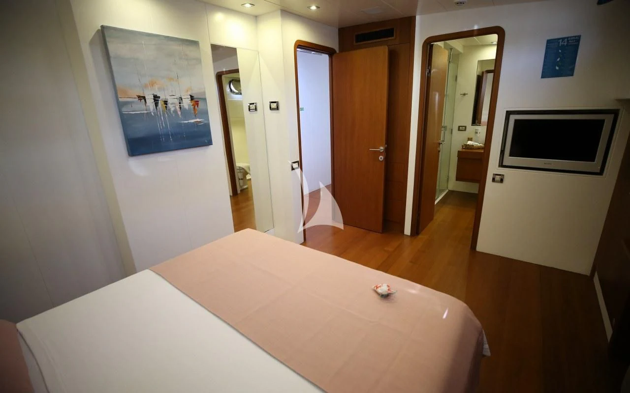 a room with a table and a tv on the wall aboard UBI BENE Yacht for Charter