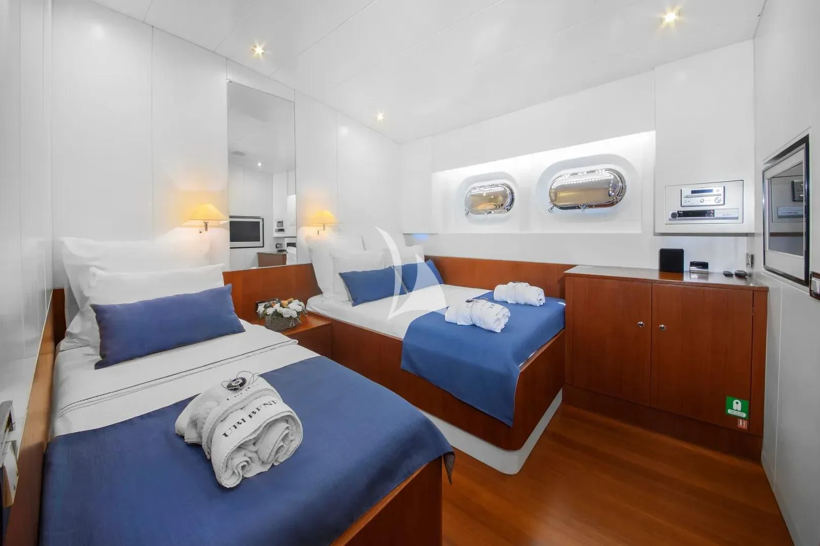 a room with beds and a television aboard UBI BENE Yacht for Charter