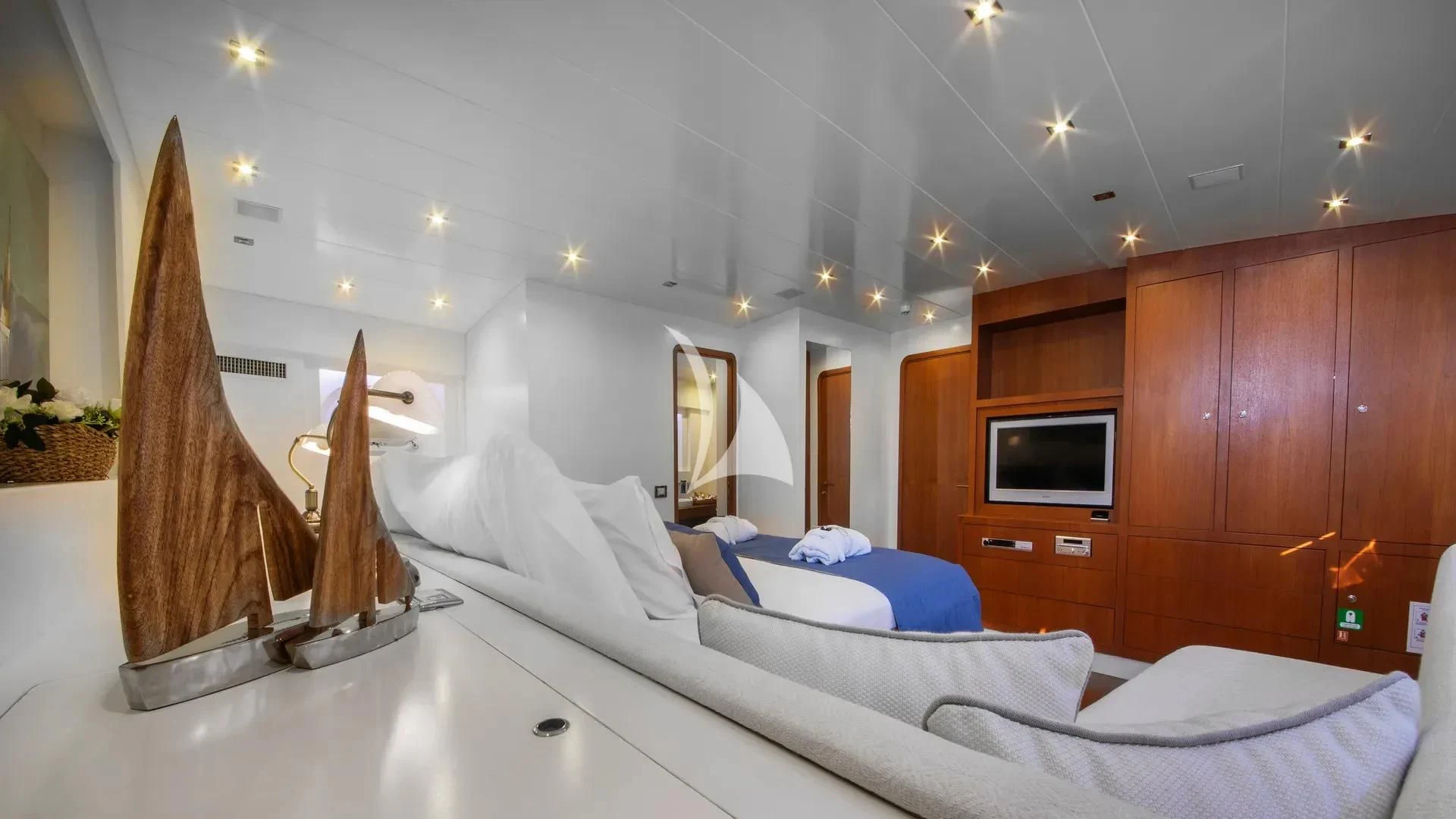 a bedroom with a bed and a television aboard UBI BENE Yacht for Charter