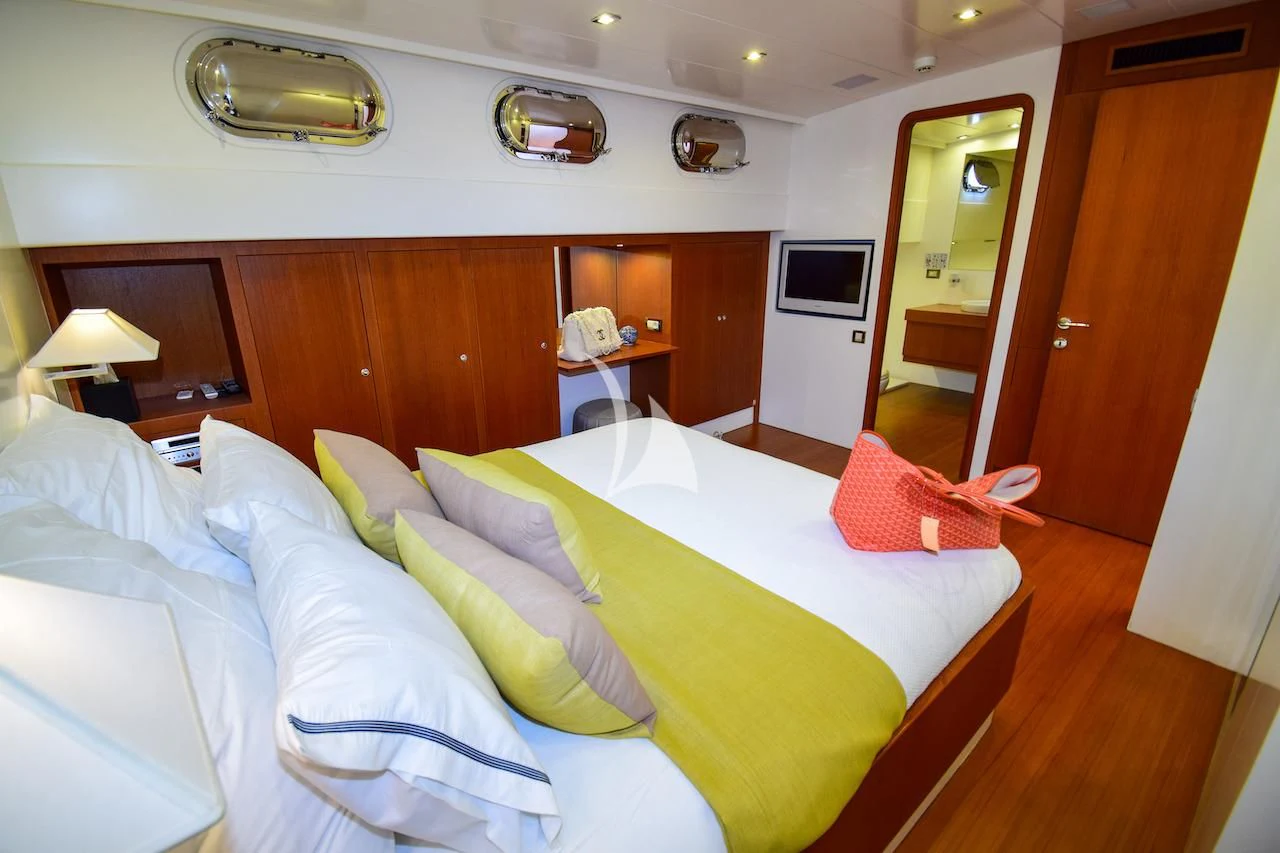 a bedroom with a bed and a television aboard UBI BENE Yacht for Charter