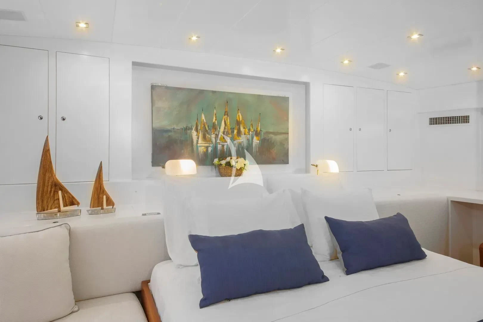 a white bedroom with a large painting aboard UBI BENE Yacht for Charter