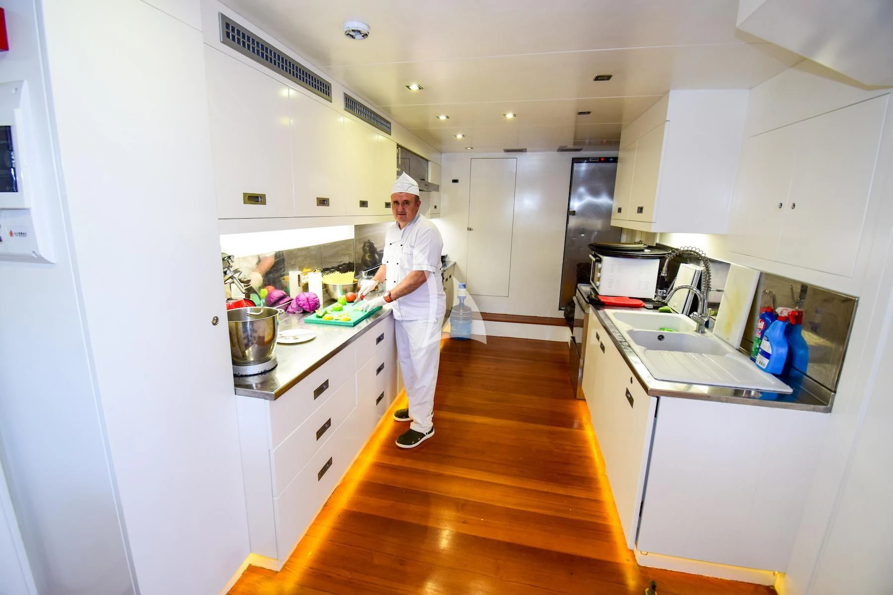 a chef in a kitchen aboard UBI BENE Yacht for Charter