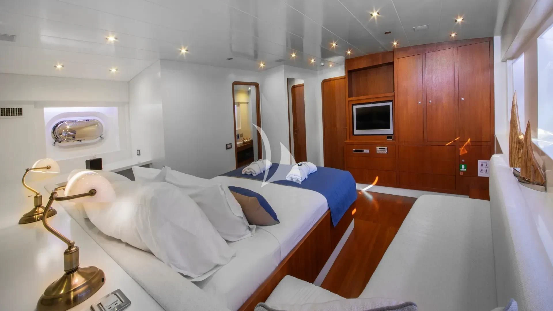 a room with a bed and a television aboard UBI BENE Yacht for Charter