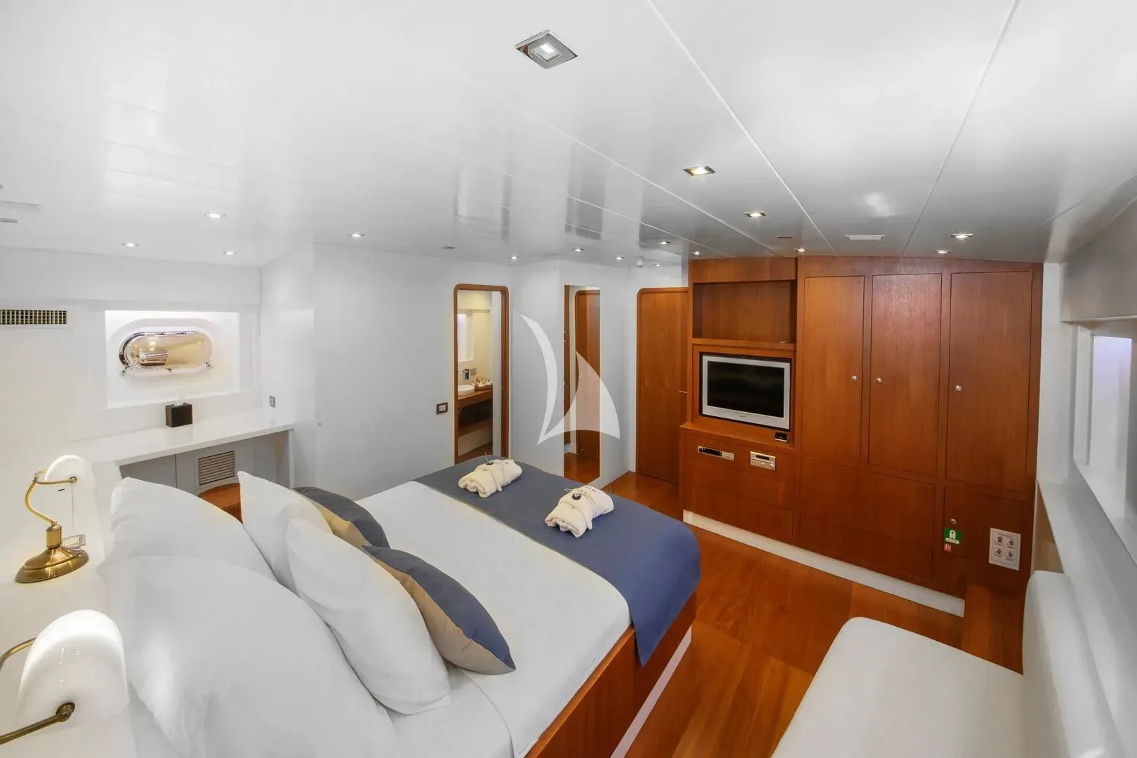 a bedroom with a bed and a wood cabinet aboard UBI BENE Yacht for Charter
