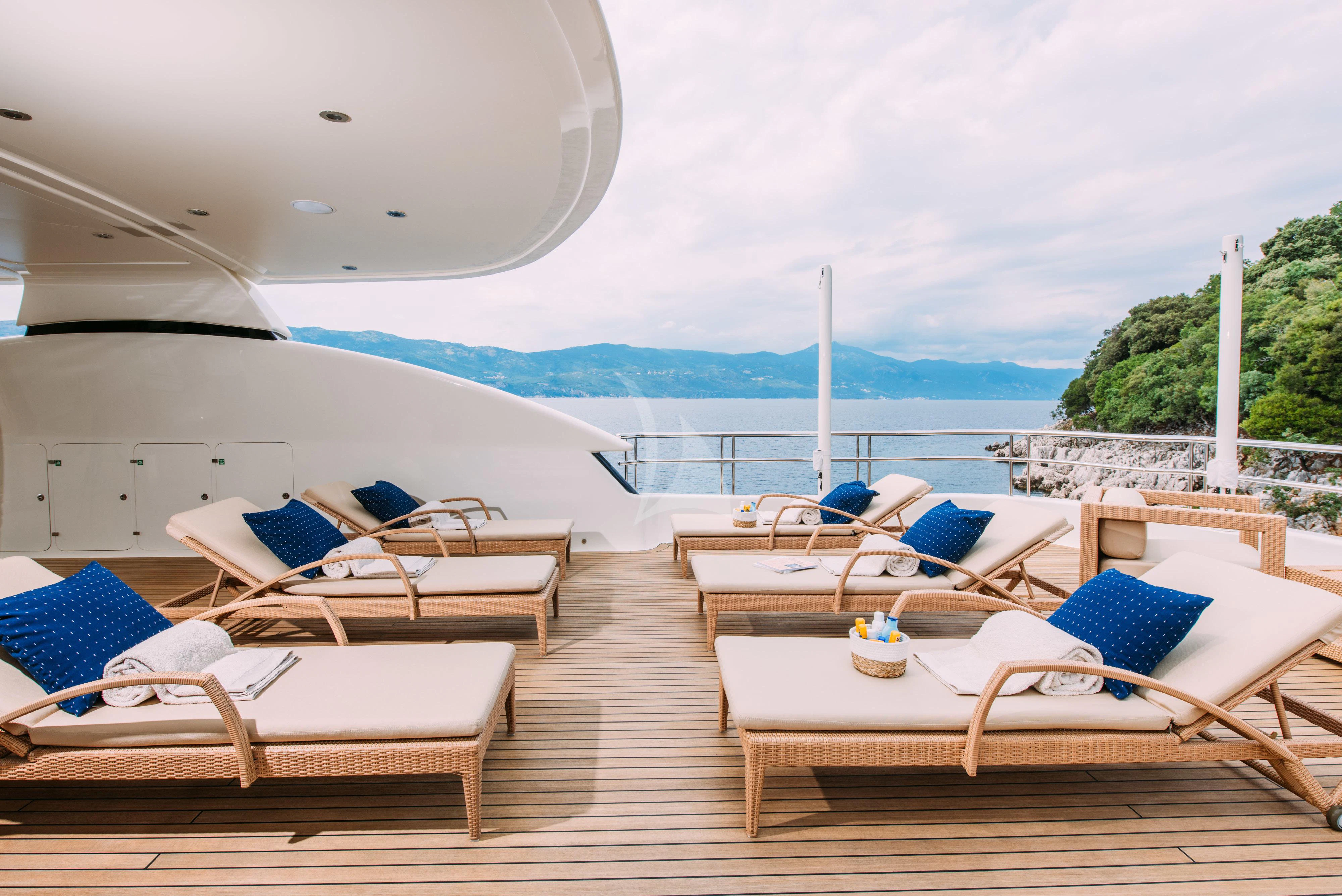 a group of lounge chairs on a deck overlooking a body of water aboard TIREA Yacht for Sale
