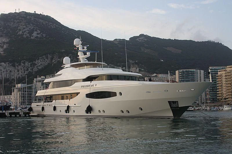 a large white yacht in a harbor aboard TIREA Yacht for Sale