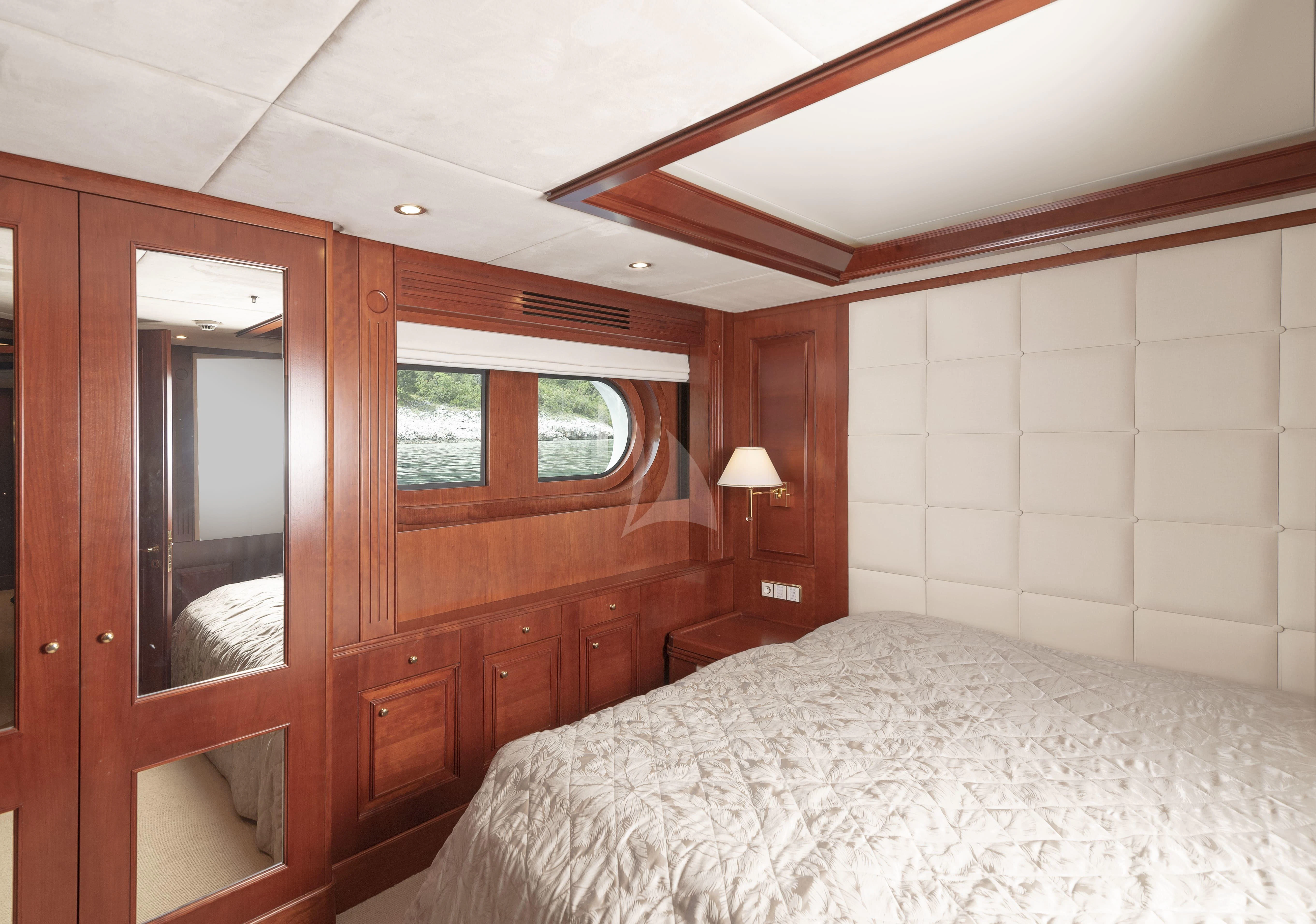 a bedroom with a bed and a mirror aboard TIREA Yacht for Sale