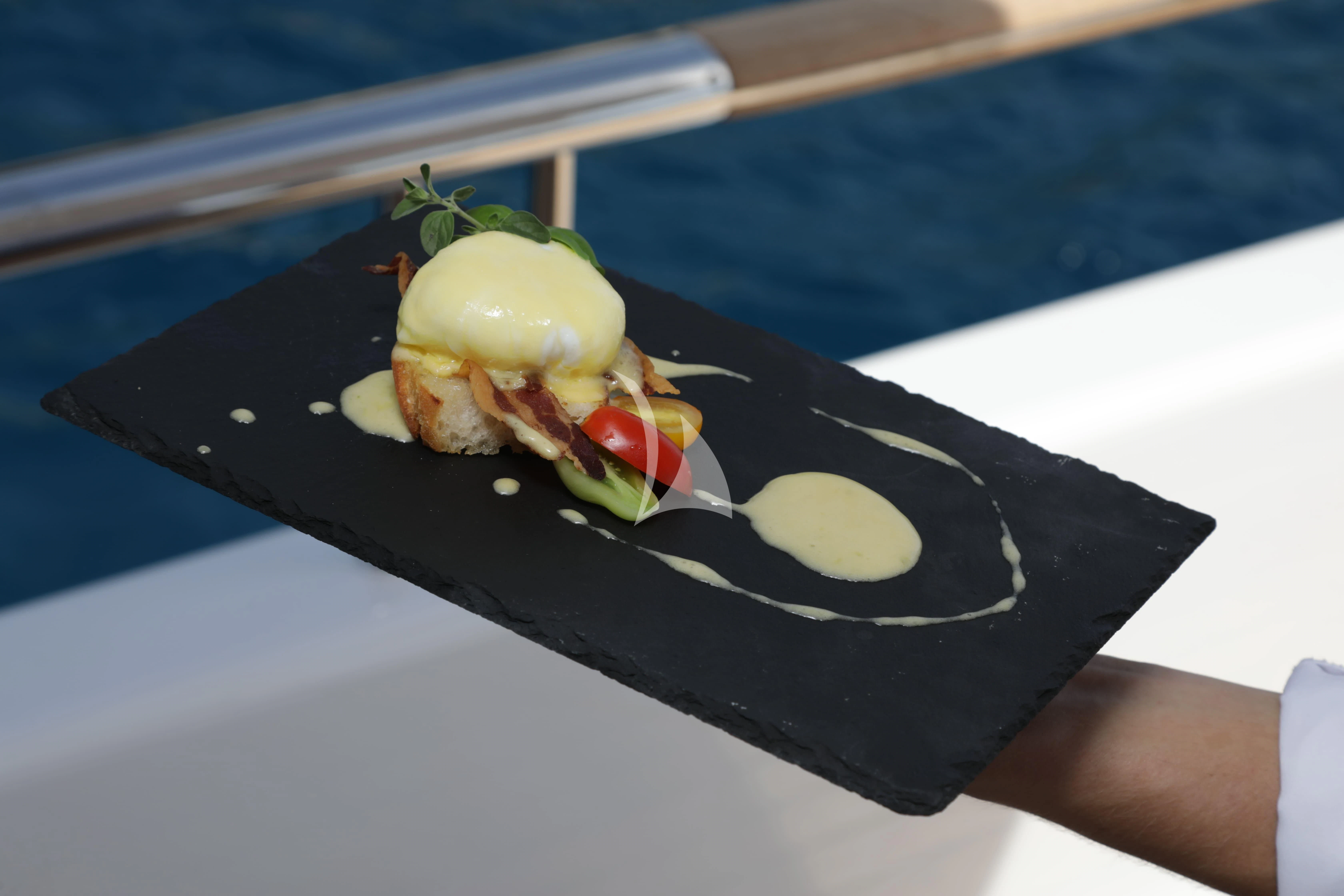 a black plate with food on it aboard TIREA Yacht for Sale