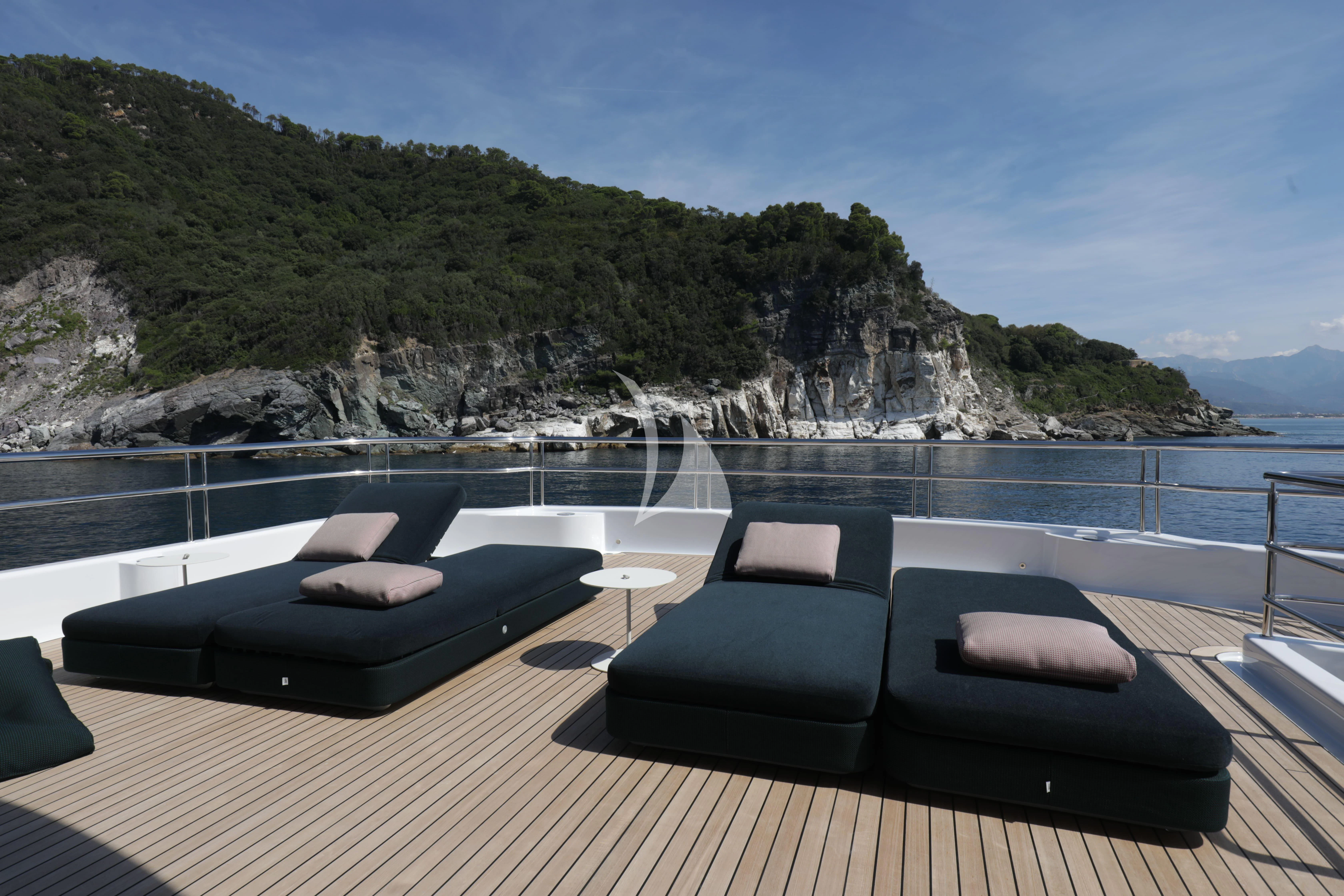 a deck with a view of a large body of water and mountains aboard TIREA Yacht for Sale