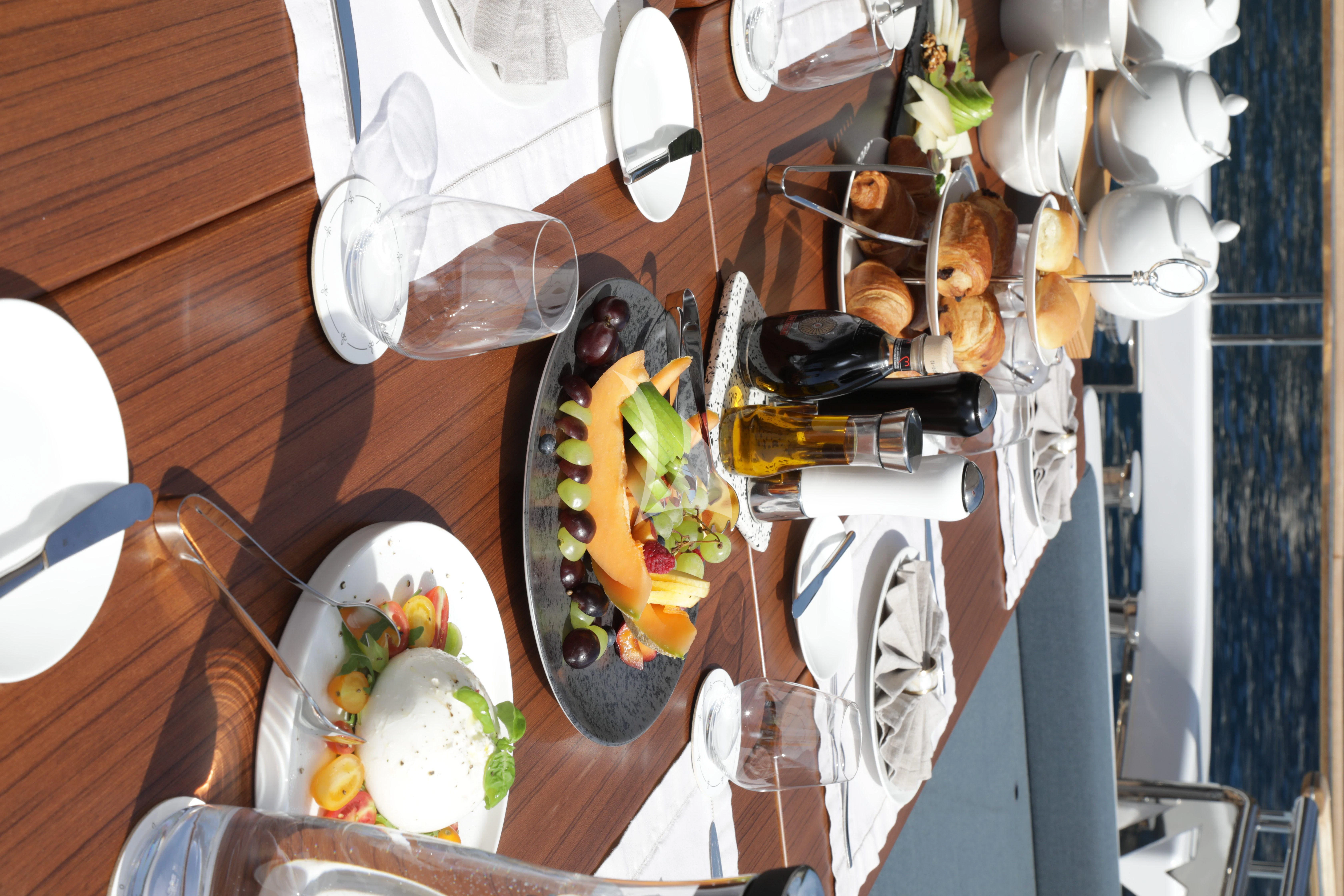 a table with food and plates aboard TIREA Yacht for Sale