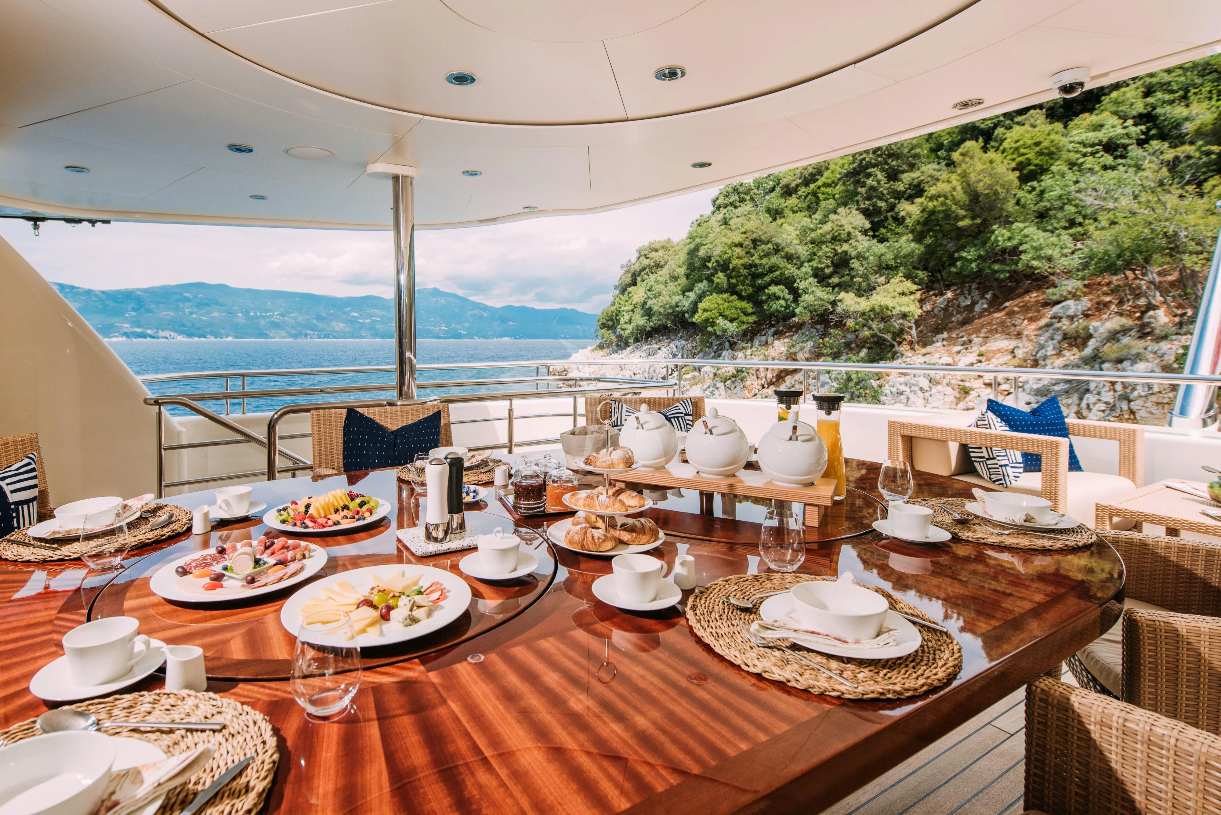 a table with plates and food on it aboard TIREA Yacht for Sale