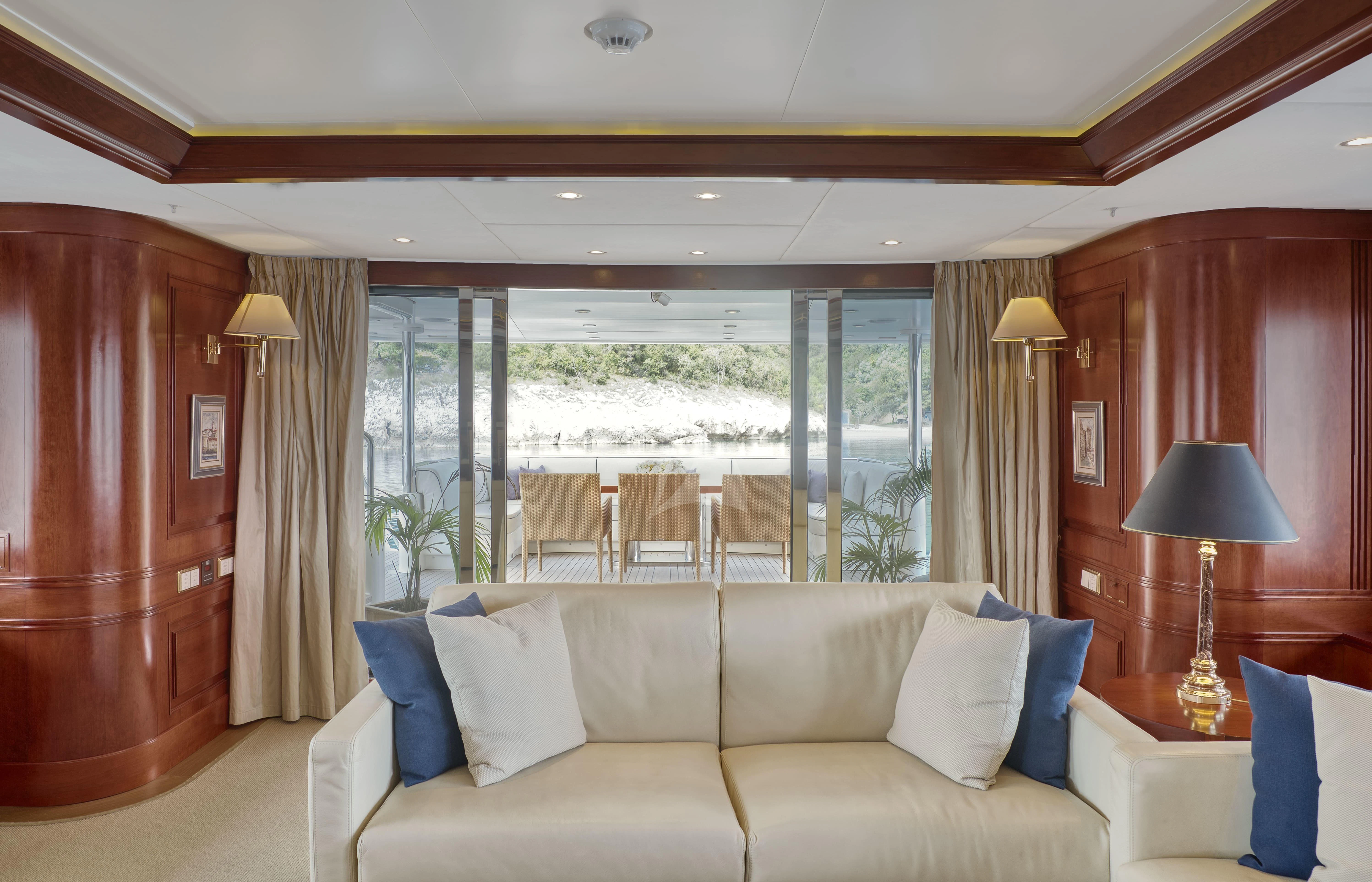 a room with a couch and a table and a lamp aboard TIREA Yacht for Sale