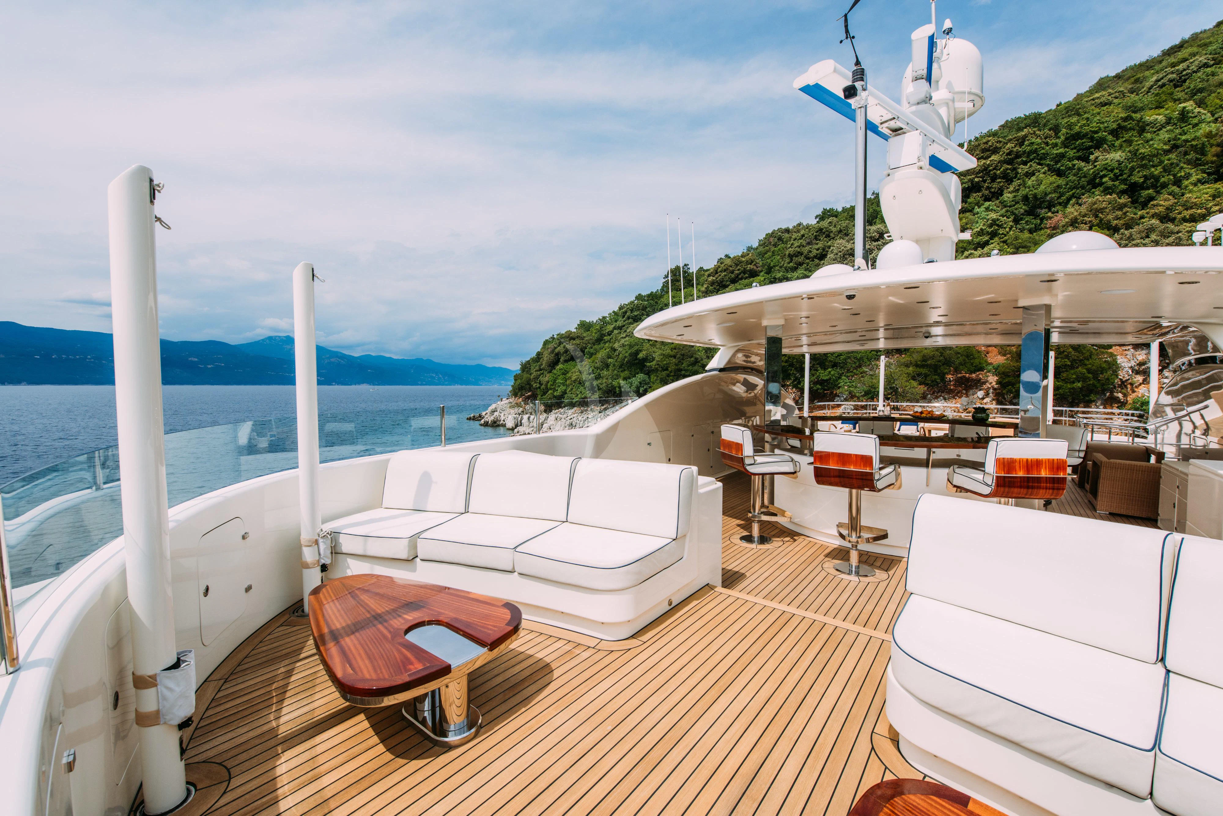 a deck with a boat and a picnic table on it aboard TIREA Yacht for Sale