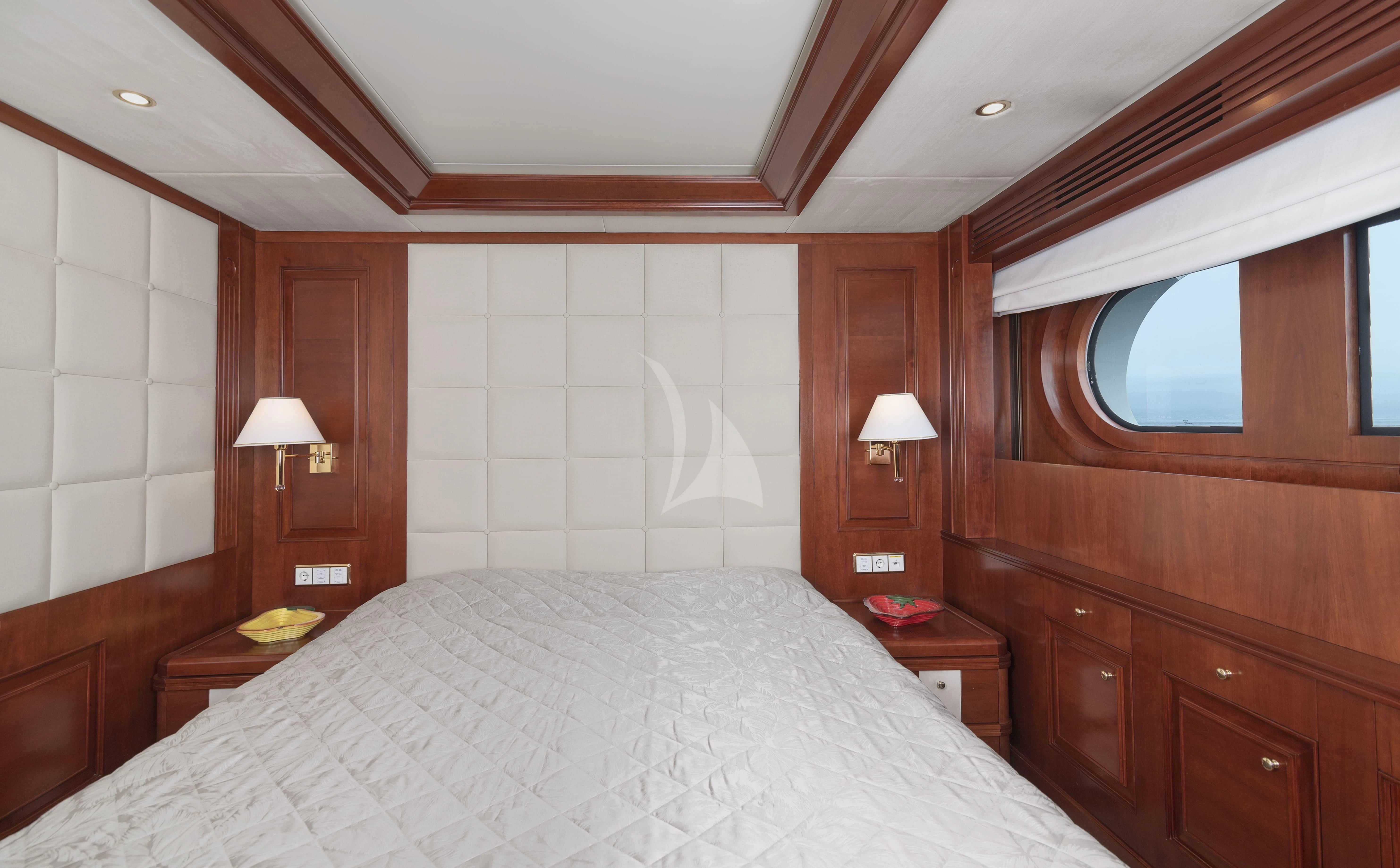 a bedroom with a bed and a window aboard TIREA Yacht for Sale