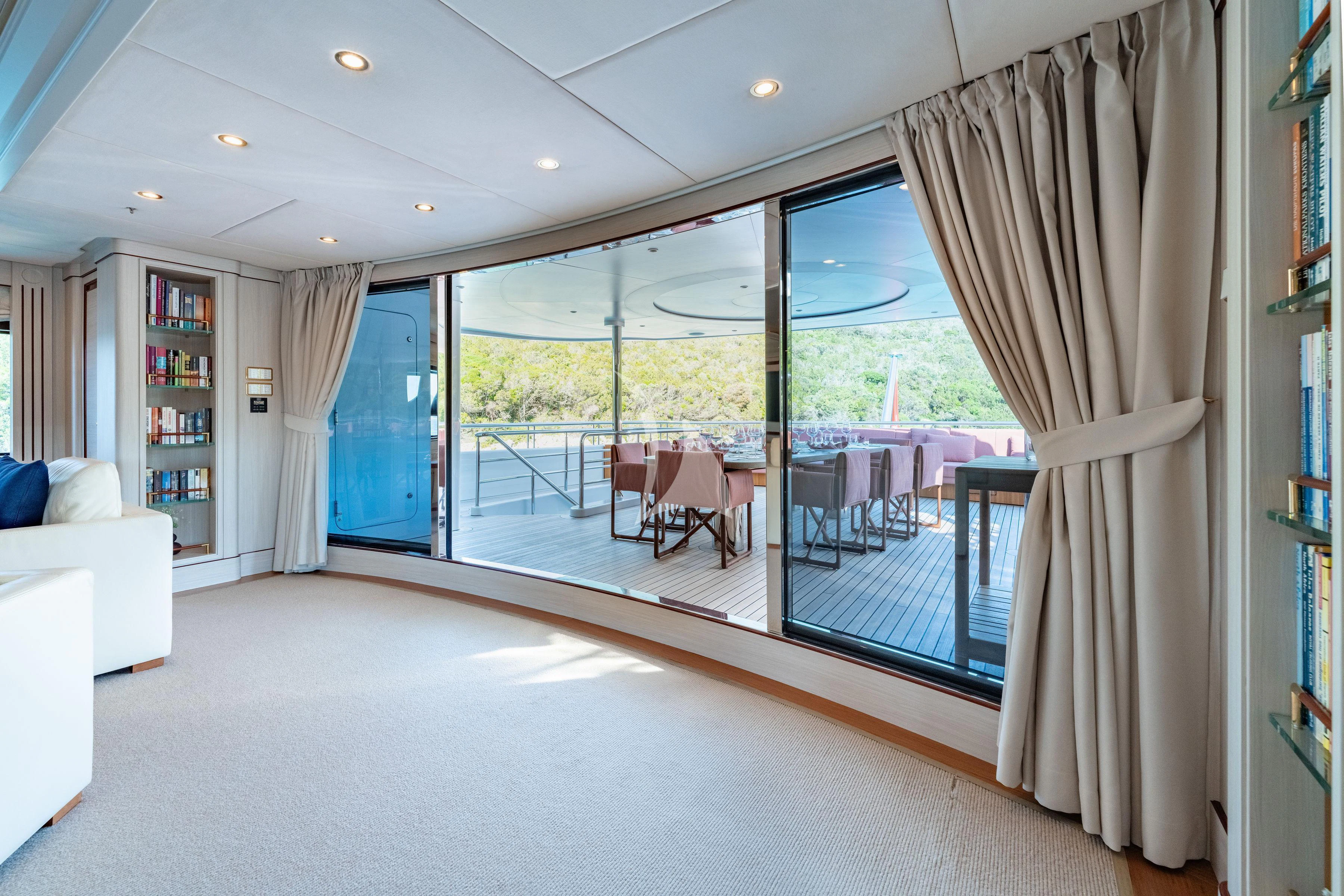 a room with a large window and a table and chairs aboard TIREA Yacht for Sale